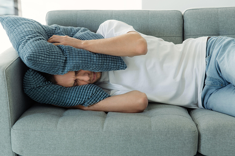 Guy holding pillows over ears